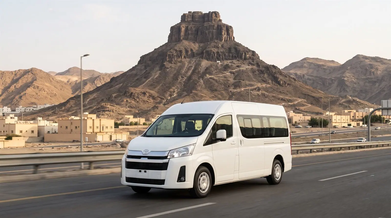 White van on a road below a mountain near Makkah